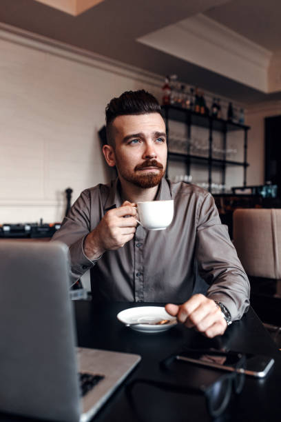 istock Businessman is working with his laptop and drinking coffee in cafe 1461791817