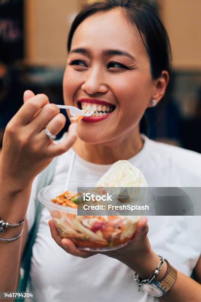 A Happy Beautiful Woman Holding Eating Some Healthy Salad Stock Photo - Download Image Now
