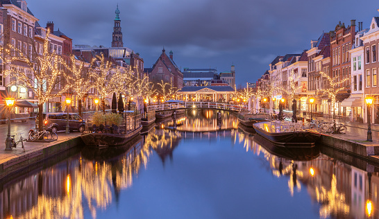 A picturesque view of the city embankment and the Christmas illumination of fairy houses at sunset. Leiden. Netherlands.