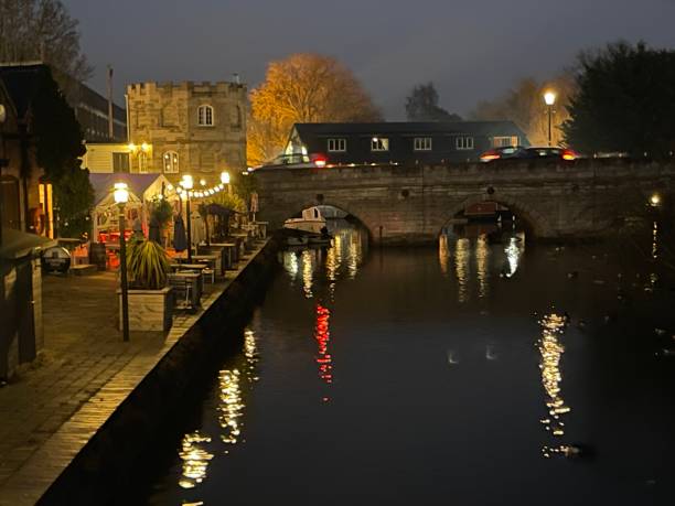 istock Night lights of a cafe glowing reflecting in river water 1461801465
