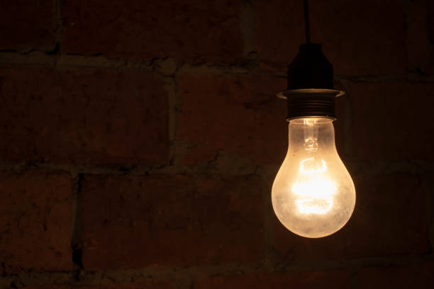 traditional light bulb glowing in a dark room