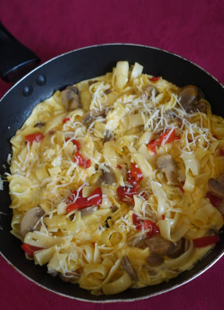 istock Frittata with pasta Cheese Red Pepper Mushrooms in a frying pan 1461805257