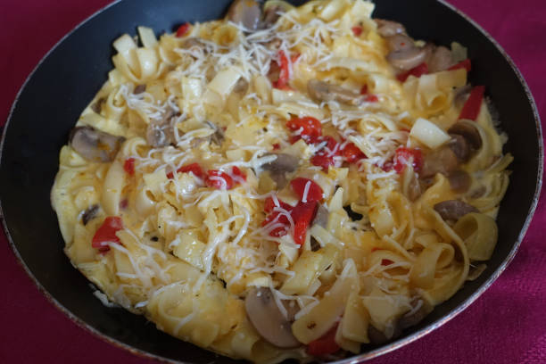 istock Frittata with pasta Cheese Red Pepper Mushrooms in a frying pan 1461805268