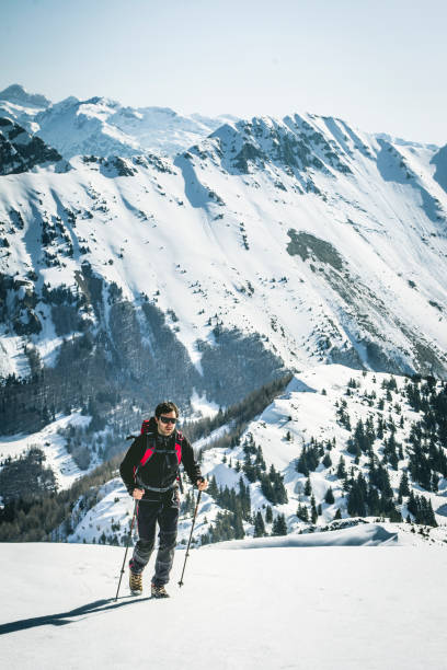 istock Young man hiking up the mountain in fresh snow 1461805433