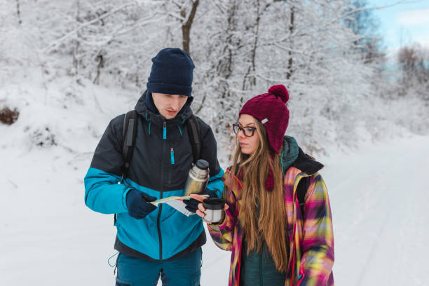istock Two lost young hikers looking at the map while taking a break from hiking and drinking hot tea 1461812904