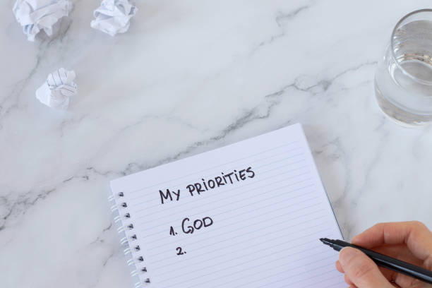 istock God first, top priorities list, handwritten text on a spiral notebook with human hand holding black marker 1461816387