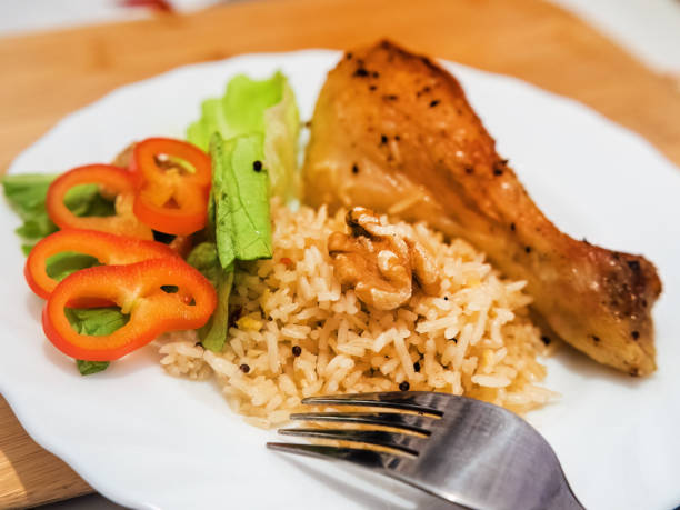 istock Delicious chicken drumstick with rice and vegetables on the plate 1461825530