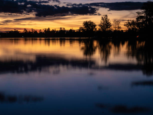 Long exposure sunset reflections on lake stock photo