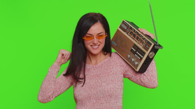 Woman using retro tape record player to listen music, disco dancing of favorite track, having fun