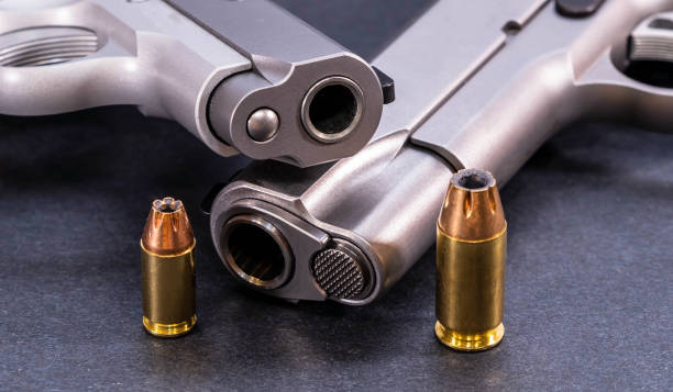 Two pistols stacked together with bullets for each of them