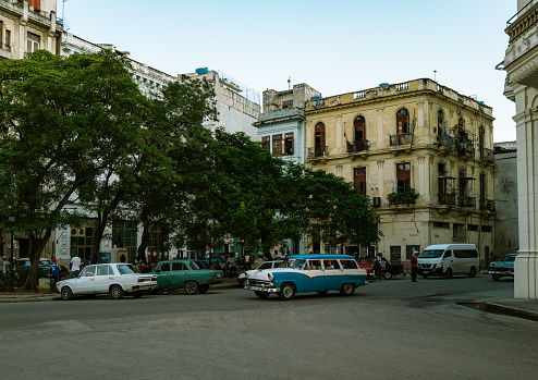 Havana, Cuba - December 9th 2022: Classic vintage cars driving along Prado Avenue at old Havana. Old Havana is one the most unique and charming places for tourists in the world for its time-capsuled buildings and lifestyles.