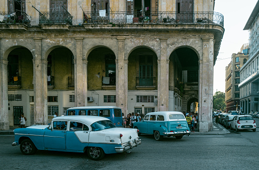 Havana, Cuba - December 13th 2022: Classic vintage cars driving along at old Havana. Old Havana is one the most unique and charming places for tourists in the world for its time-capsuled buildings and lifestyles.