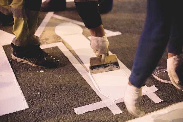 Process of making new road surface markings with a line striping machine, workers improve city infrastructure, demarcation marking of pedestrian crossing with hot melted paint on asphalt pavement proceso de hacer nuevas marcas de superficie vial con máquina de rayado de líneas, los trabajadores mejoran la infraestructura de la ciudad, la demarcación del paso de peatones con pintura derretida en caliente en el pavimento de asfalto