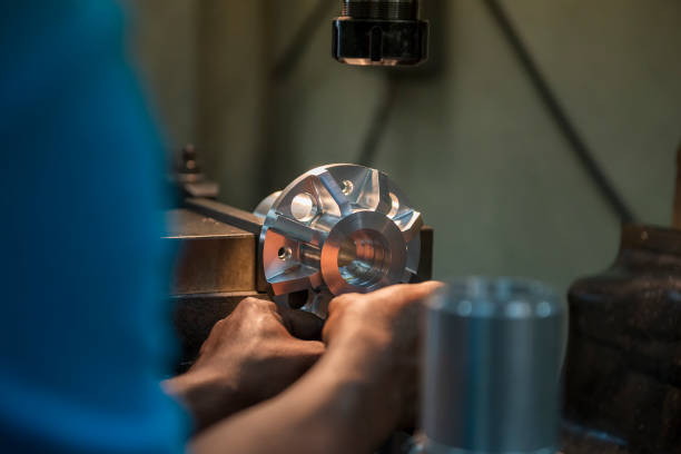 The machine operator setup the metal parts with NC milling machine.