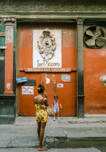 Havana, Cuba - December 8th 2022: Locals and tourists enjoying cuban daily life on the street of old Havana. Havana is one of the most unique places to visit for its time-capsuled buildings and cars and lifestyles.