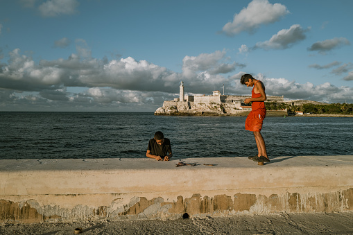 Havana, Cuba - December 10th 2022: The Malecón, Old Havana, Cuba, Fisherman at the entrance of the Havana bay, in front of the Morro Castle. Malecon is one the most popular attractions in Havana both to tourists and locals.