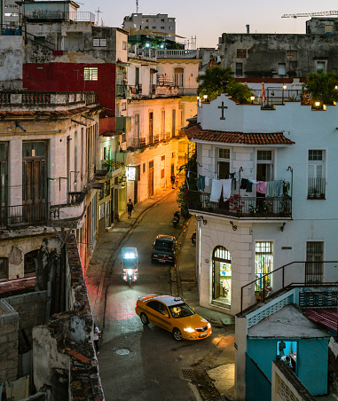 Havana, Cuba - December 9th 2022: Locals and tourists enjoying dusk hour of old Havana. Havana is one of the most unique places to visit for its time-capsuled buildings and cars and lifestyles.