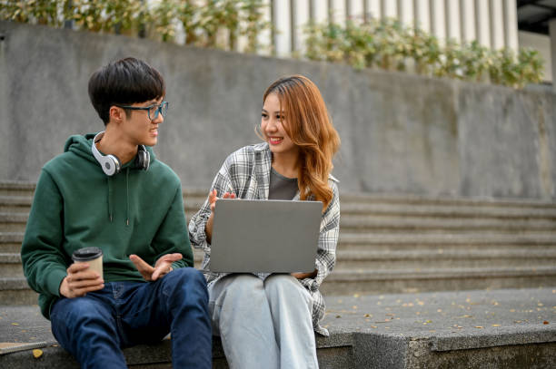 istock Happy Asian college students are talking, working on their school project on laptop 1461922764
