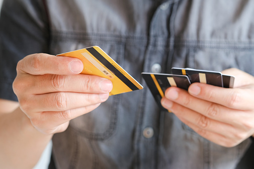 Man holding several credit cards and he is choosing a credit card to pay and spend Payment for goods via credit card. Finance and banking concept.