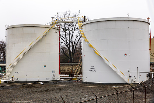 2 large white industrial fuel storage tanks side by side.  Spiral straircase up front of each,  One tank labeled Diesel, the other tank labeled Super Gasoline.