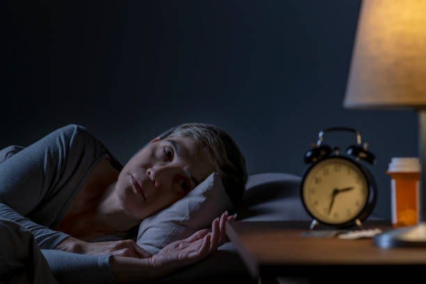 депрессия старшая женщина, лежащая в постели не может спать от бессонницы - insomnia стоковые фото и изображения