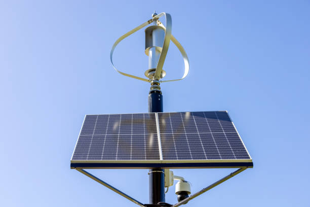 istock Small Solar Panels with Wind Turbines, front view, blue sky background with copy space 1461959722