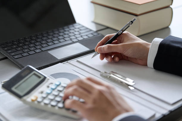 Hand of a man studying money-related qualifications stock photo