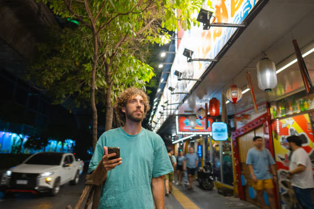 istock Man holding smartphone while walking in Tokyo at night 1462015418