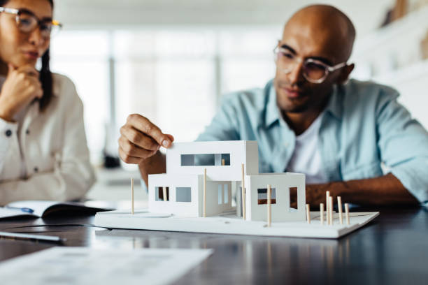 istock Architect discussing his 3D house model with a colleague 1462023872