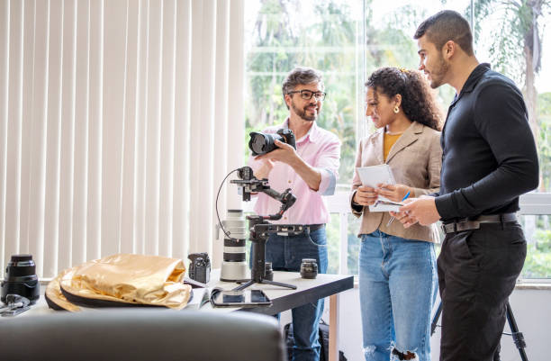 istock Photographer teaching two students about cameras in a studio 1462034304