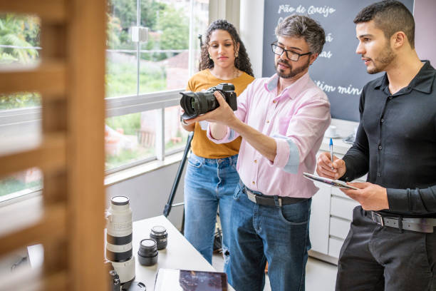 fotograf unterrichtet studenten in seinem studio über kameraausrüstung - üben fotos stock-fotos und bilder