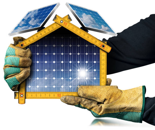 Hands with protective work gloves holding a small model house with solar panels. Isolated on white background with reflections.