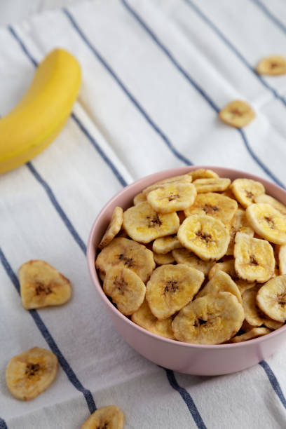 istock Homemade Banana Chips in a Pink Bowl, side view. 1462035250
