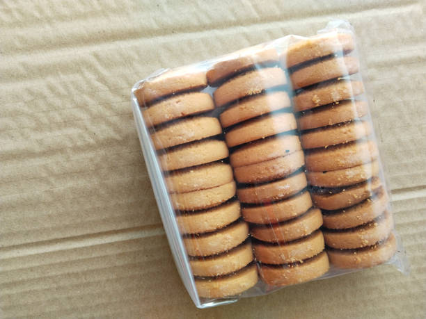 istock Packing cookies on a brown background. Biscuits in plastic packaging. copy space, place your text 1462050230