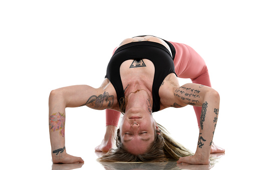 Woman practicing yoga (tattoos are original artwork).