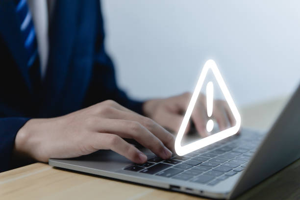 istock Businessman using laptop warned of dangerous problems caution 
 that shows a warning triangle and an exclamation mark icon. 1462055623
