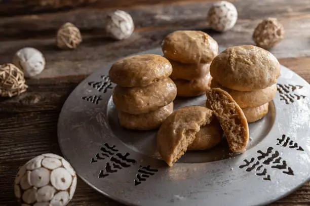 Homemade fresh baked gingerbread cookies on a christmas silver plate with decoration on wooden table background. Closeup