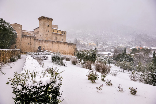 Gualdo Tadino, Umbria, Italy, January 21 -- An idyllic winter scene with a snow covered castle in the medieval village of Gualdo Tadino in Umbria, central Italy. The Umbria region, considered the green lung of Italy for its wooded mountains, is characterized by a perfect integration between nature and the presence of man, in a context of environmental sustainability and healthy life. In addition to its immense artistic and historical heritage, Umbria is famous for its food and wine production and for the high quality of the olive oil produced in these lands. Image in high definition quality.