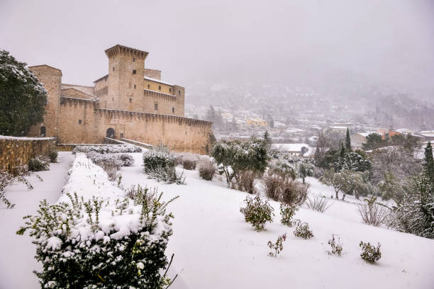 A beautiful winter scene in a medieval small town in Umbria in central Italy with a castle and snow-covered streets Gualdo Tadino, Umbria, Italy, January 21 -- An idyllic winter scene with a snow covered castle in the medieval village of Gualdo Tadino in Umbria, central Italy. The Umbria region, considered the green lung of Italy for its wooded mountains, is characterized by a perfect integration between nature and the presence of man, in a context of environmental sustainability and healthy life. In addition to its immense artistic and historical heritage, Umbria is famous for its food and wine production and for the high quality of the olive oil produced in these lands. Image in high definition quality. gualdo tadino stock pictures, royalty-free photos & images