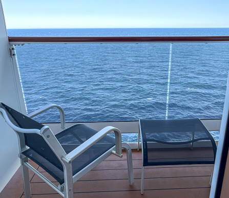 Seat and table on ship balcony at sea
