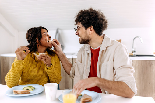 Couple having fun in the kitchen while having a breakfast