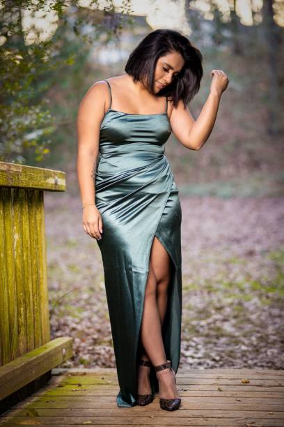 istock Beautiful Hispanic model posing in a green dress outdoors during sunrise 1462070535
