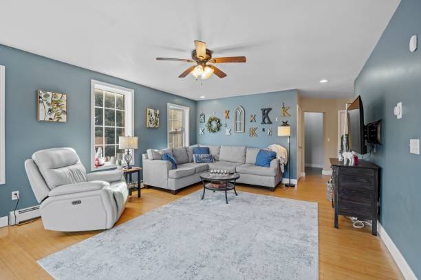 istock Beautiful suburban house interior with blue walls and sofas under a ceiling fan 1462072128