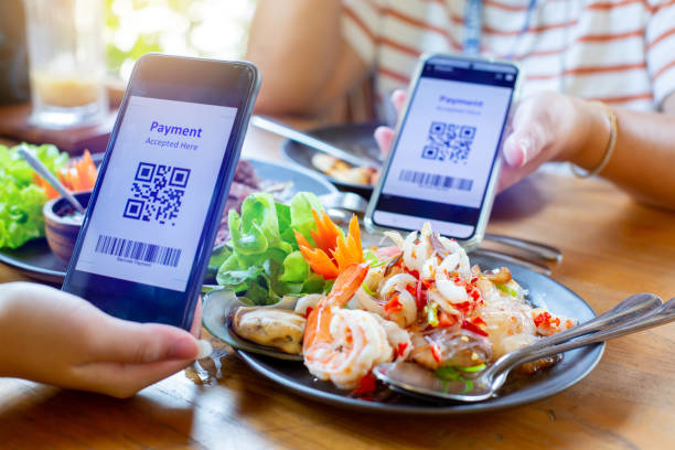 istock Selective focus to smartphone in hand to scan QR code on tag with blurry spicy Thai food. 1462084871