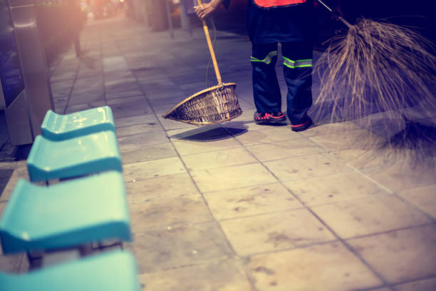 istock Selective focus to dustpan with blurry cleaning staff and broom. 1462085093