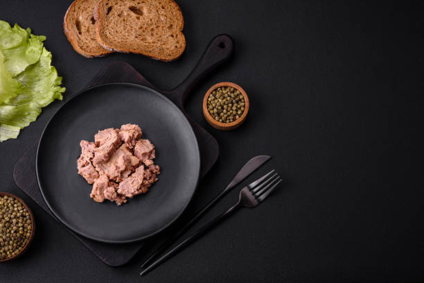 istock Delicious canned tuna meat on a black ceramic plate on a dark concrete background 1462085886