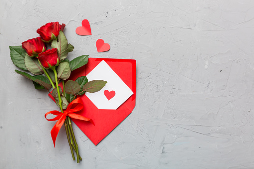 Valentine day composition with Envelope, rose flower and Red heart on table. Top view, flat lay. Holiday concept.