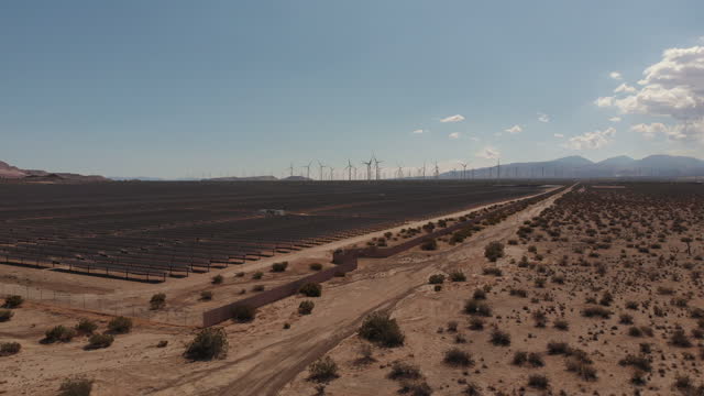 Tranquil view of solar power plants and wind turbines in the background in the Mojave Desert