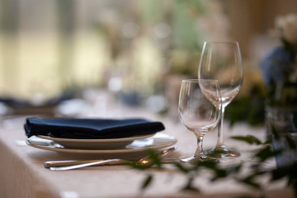 istock Closeup of a festive table with white dishes and glasses, blurred background 1462101836