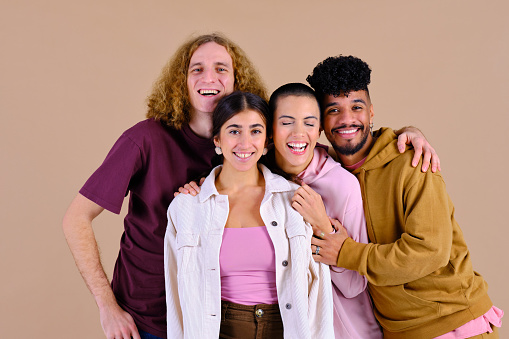 beautiful portrait of a two young men and a  two confident women with big smiles in a studio shot